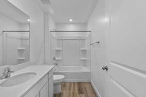 Bathroom with vanity, bathing tub / shower combination, and dark wood-style flooring