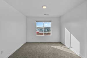 Unfurnished room featuring light colored carpet and baseboards