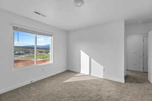 Carpeted spare room with baseboards and a mountain view