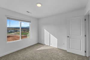 Spare room featuring light colored carpet and baseboards