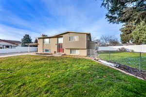 Split foyer home with brick siding, a fenced backyard, and a chimney