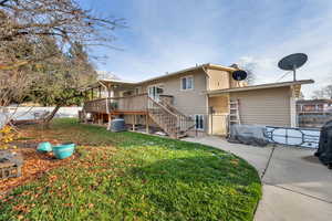 Back of house featuring stairs, a deck, and a gate