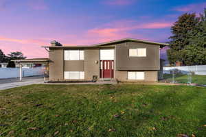 View of front of home with brick siding, a chimney, and a gate