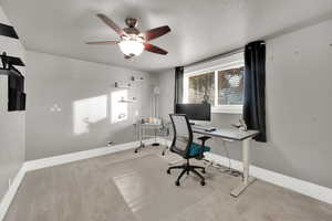 Office area with ceiling fan, light carpet, plenty of natural light, and a textured ceiling