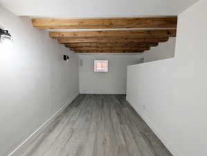 Basement featuring light woodFaux beams new windows, paint and flooring.