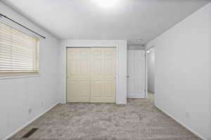 Unfurnished bedroom featuring carpet floors, a closet, and a textured ceiling
