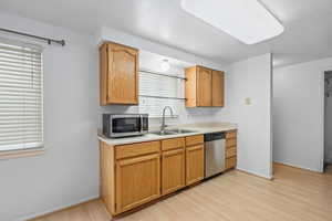 Kitchen featuring light countertops, stainless steel appliances, and light wood-style flooring
