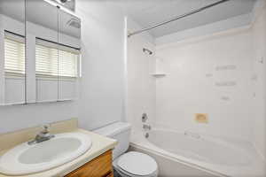 Bathroom featuring washtub / shower combination, vanity, and a textured ceiling