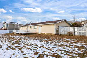 Rear view of house featuring a gate, a deck, and a garage