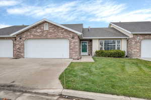 Ranch-style twin home with a garage, roof with shingles, concrete driveway, a front lawn, and brick siding