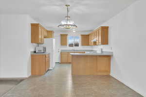 Kitchen with a peninsula and white appliances