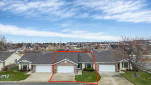 View of front of house with brick siding, roof with shingles, driveway, and a front lawn
