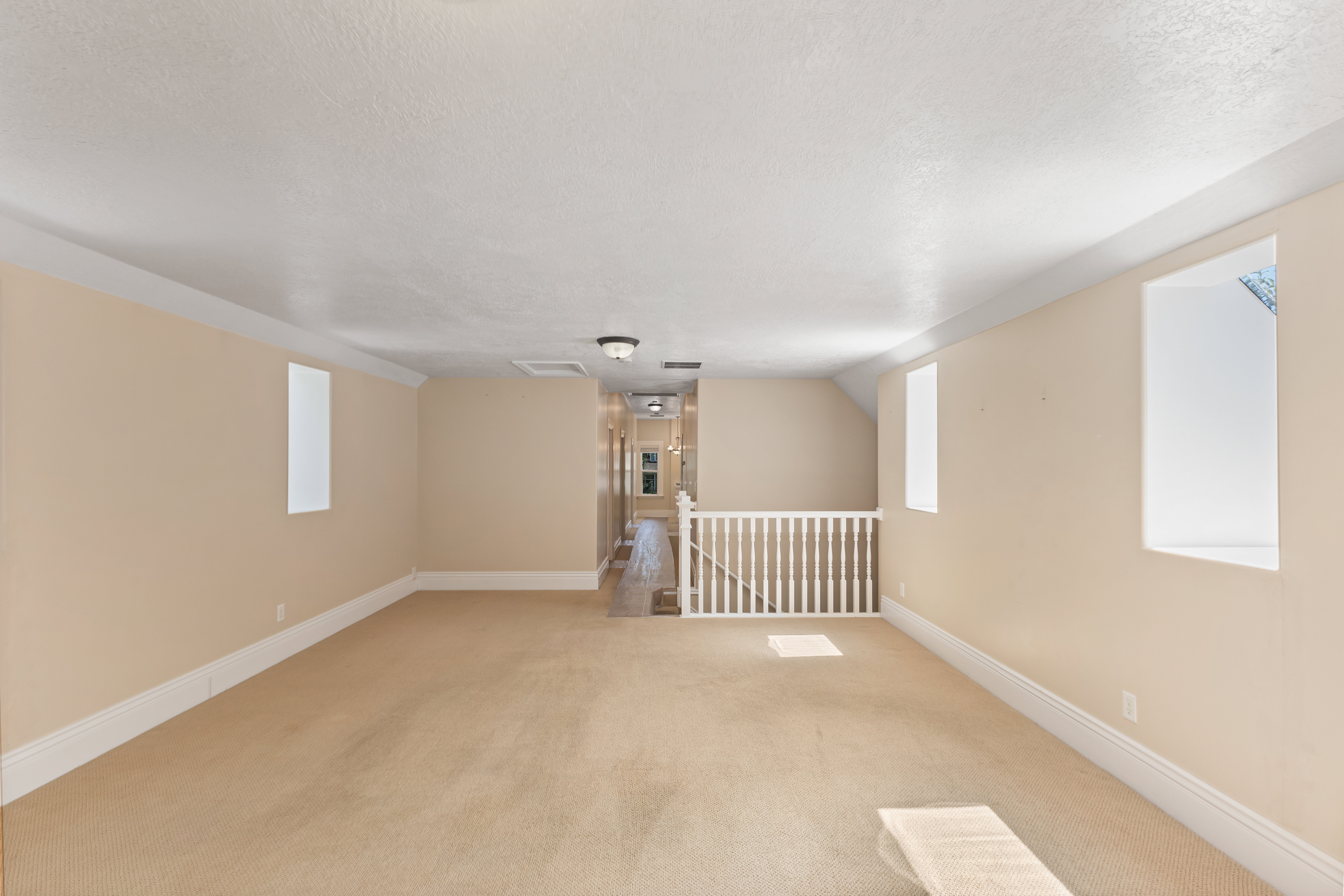 Carpeted spare room featuring a textured ceiling and vaulted ceiling