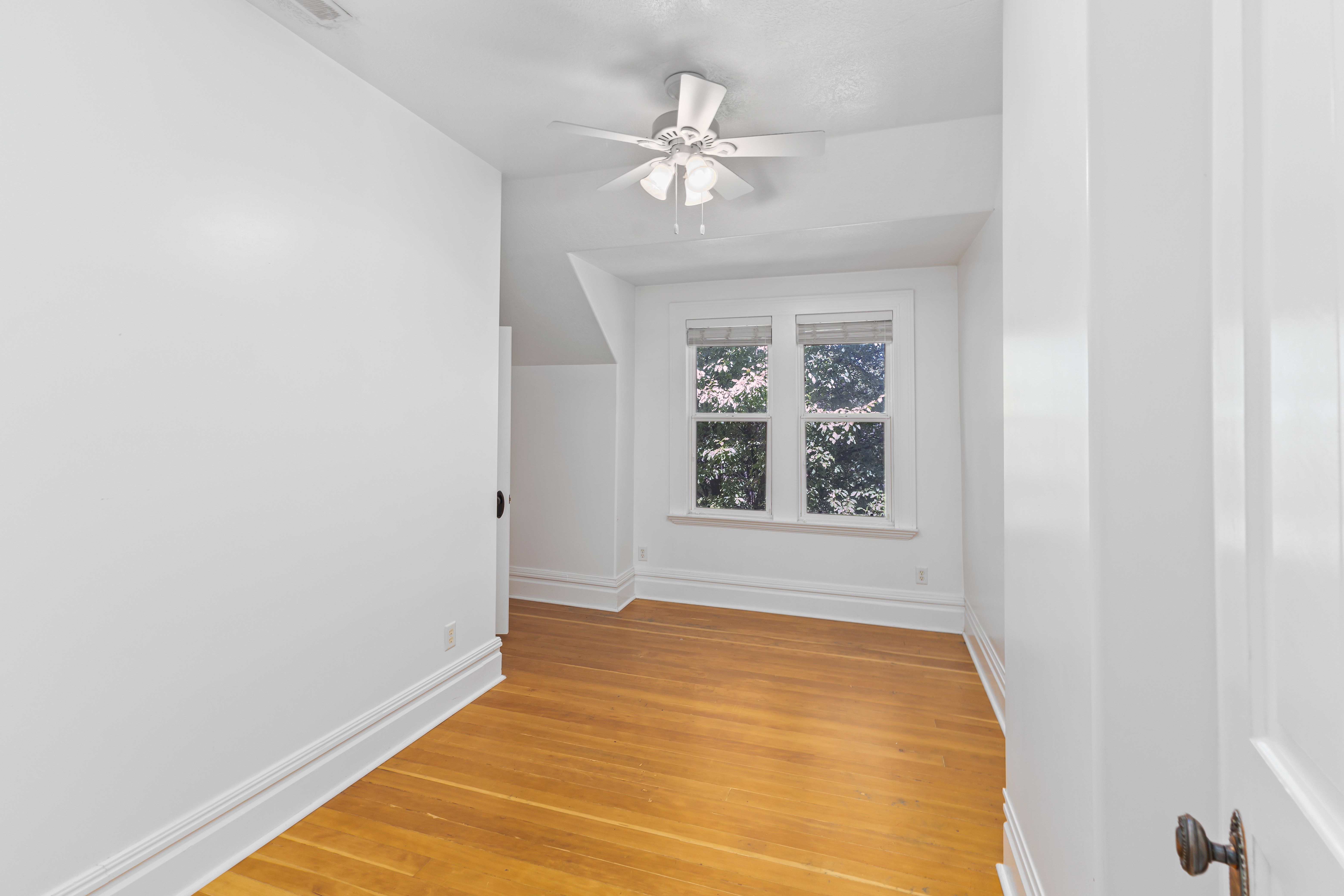 Additional living space with light wood finished floors and a ceiling fan