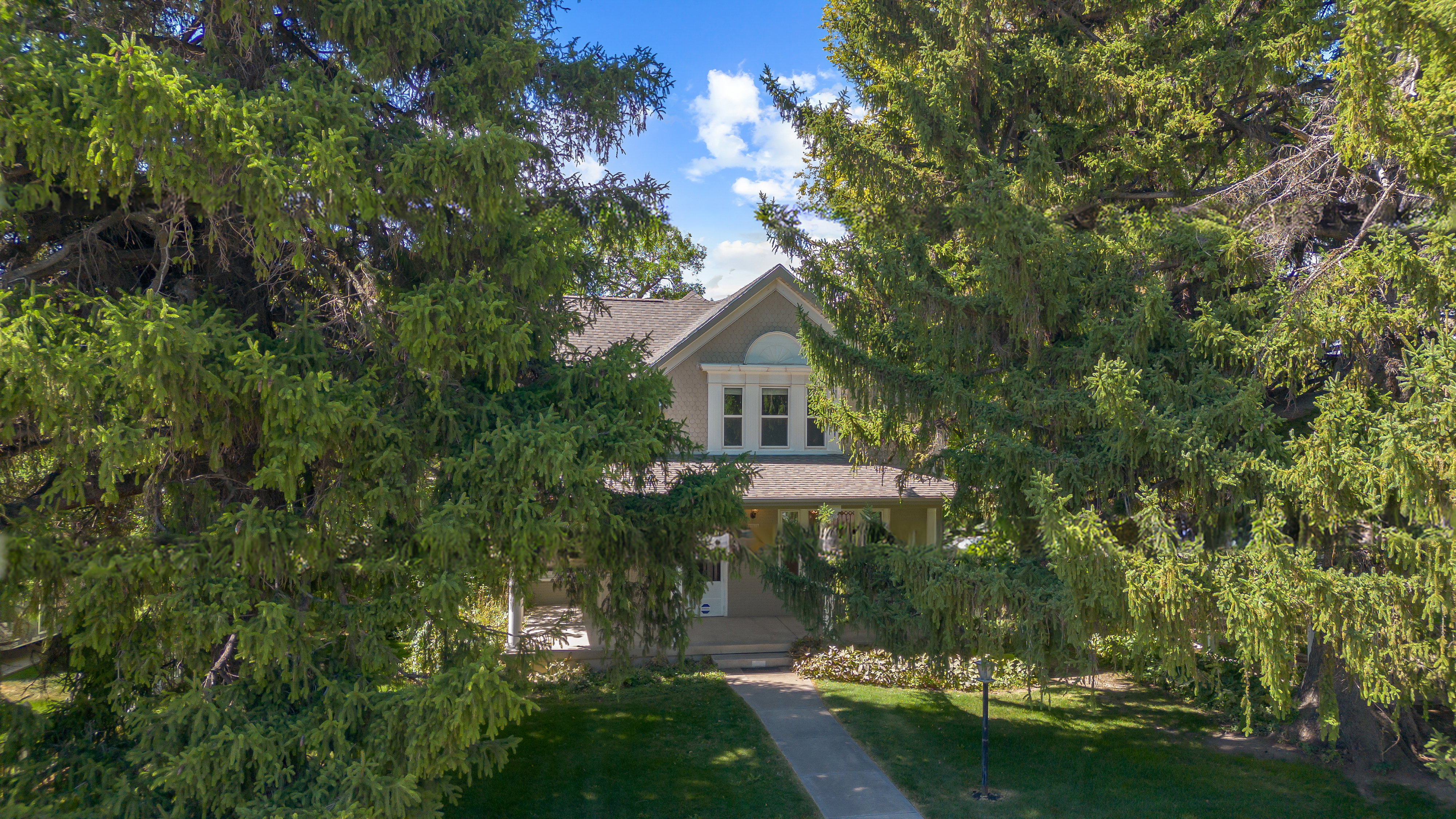 View of front of property featuring covered porch and a front yard