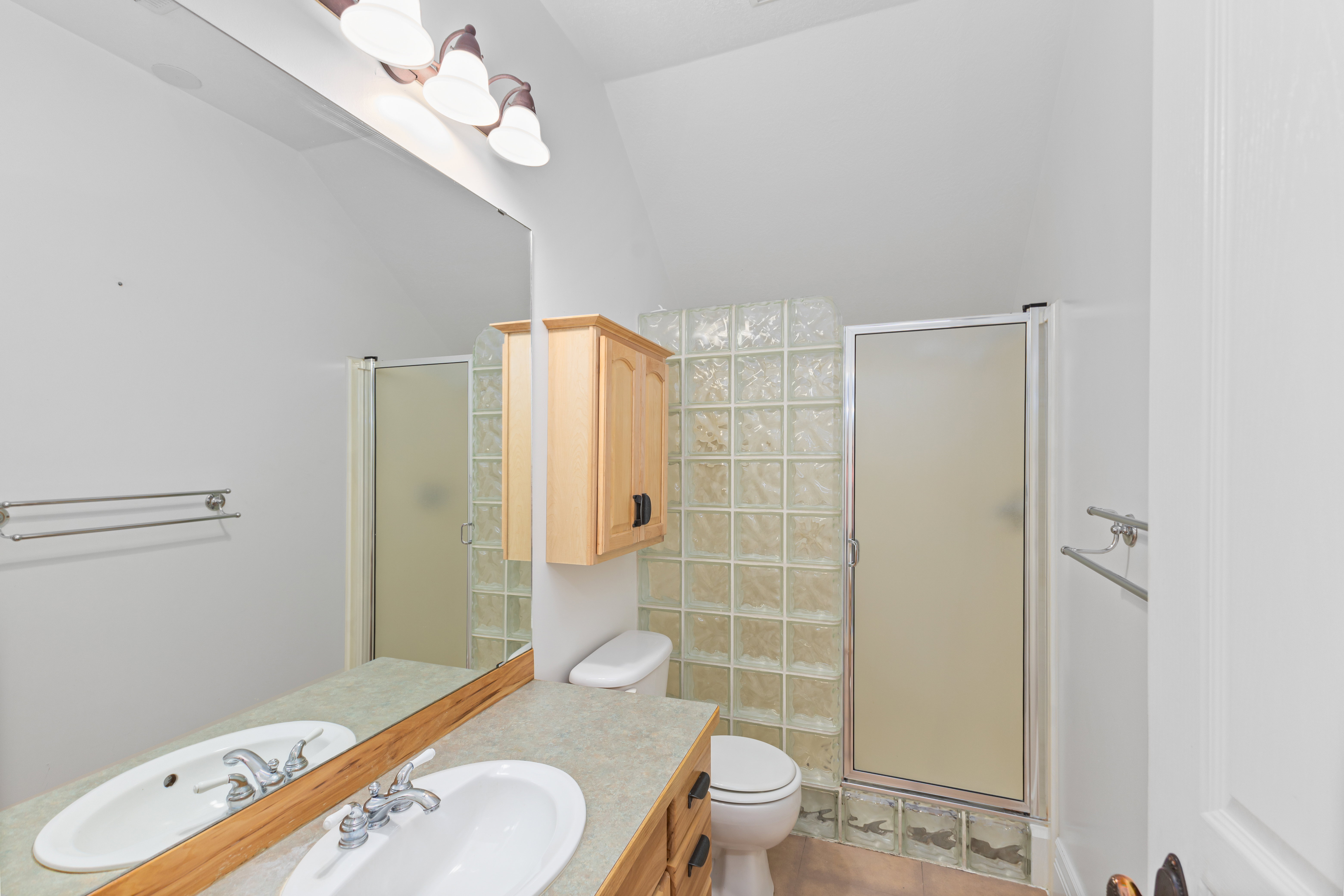 Bathroom with a stall shower, vanity, and light tile patterned flooring