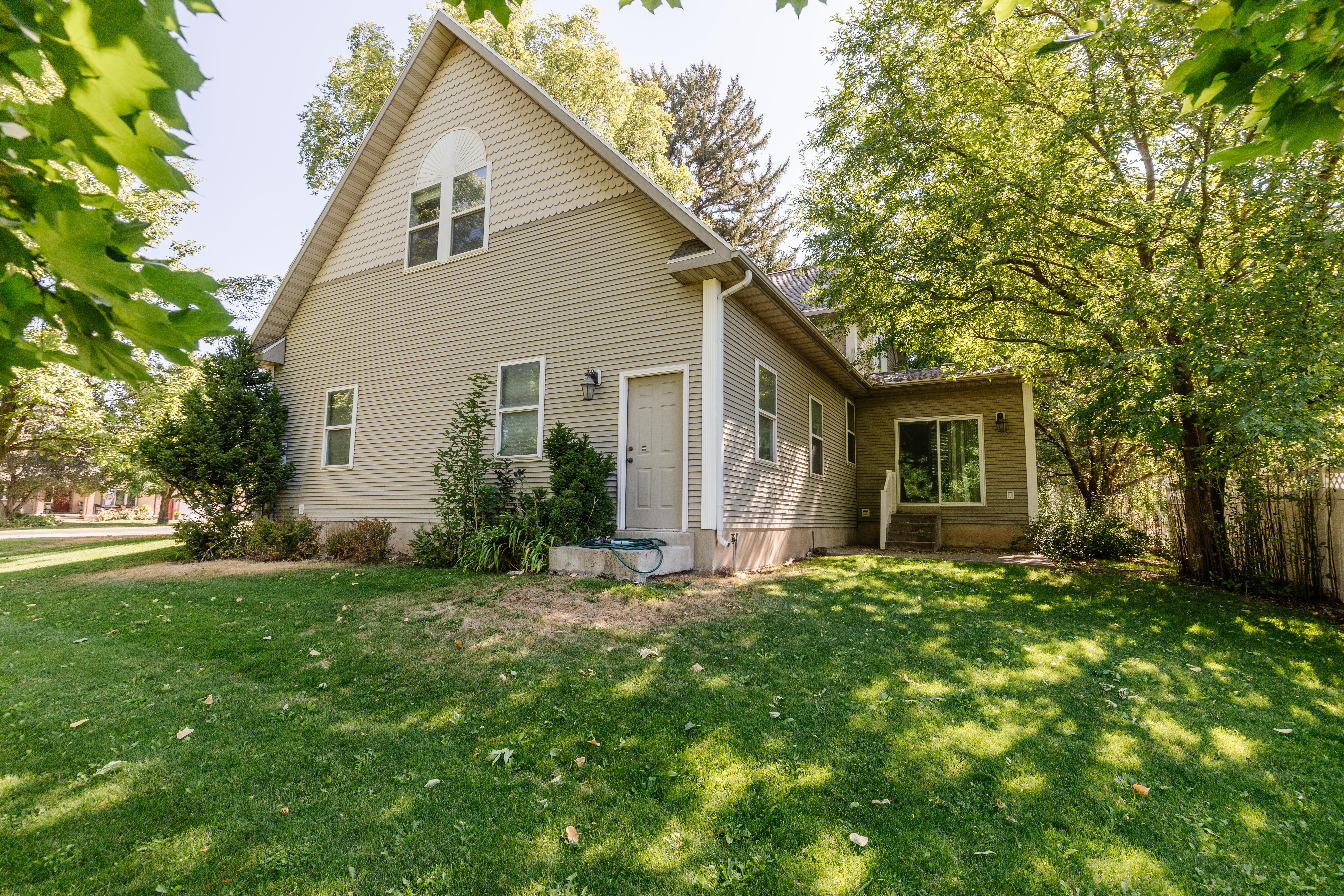 Rear view of house with entry steps and a yard