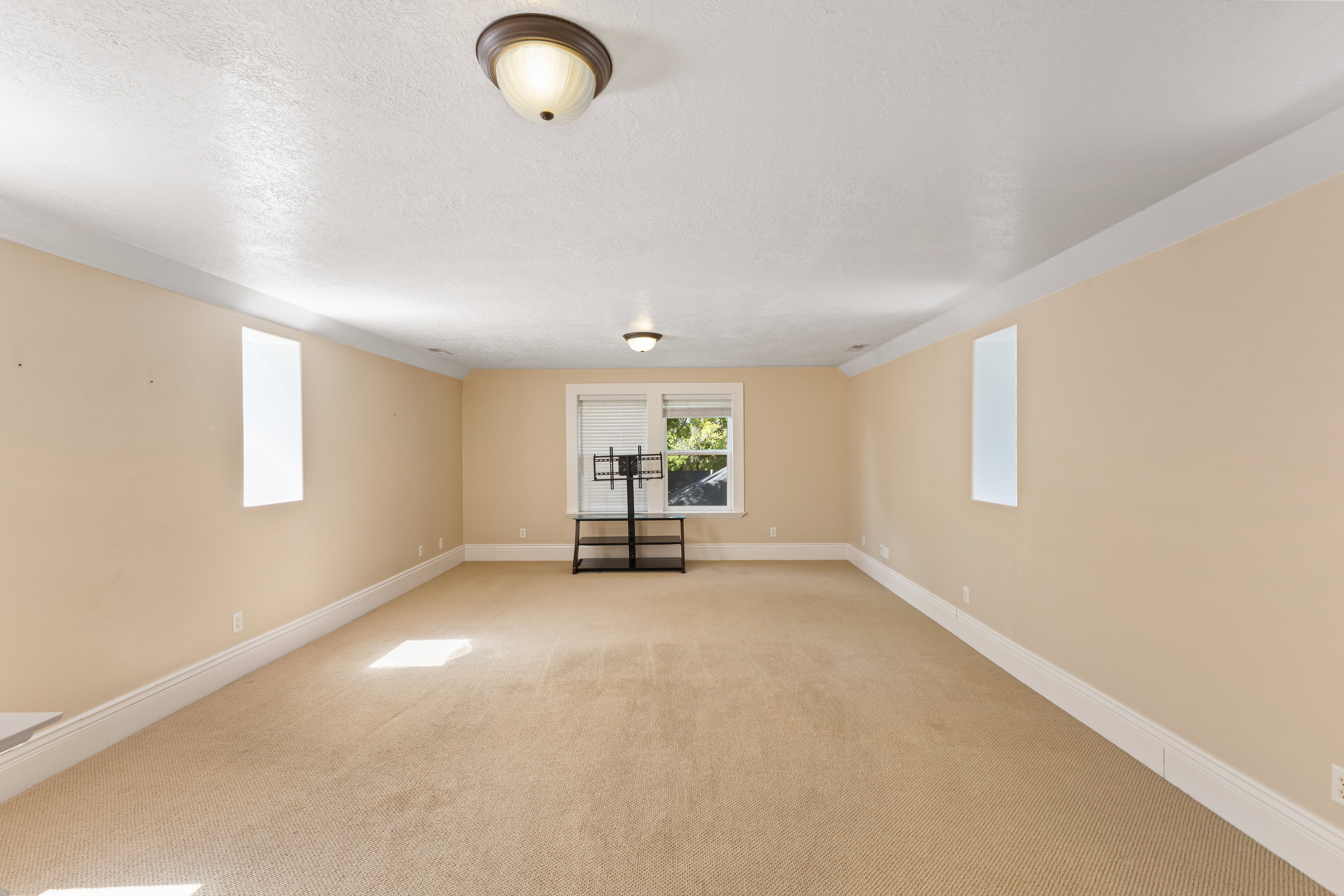 Below grade area featuring light colored carpet and a textured ceiling