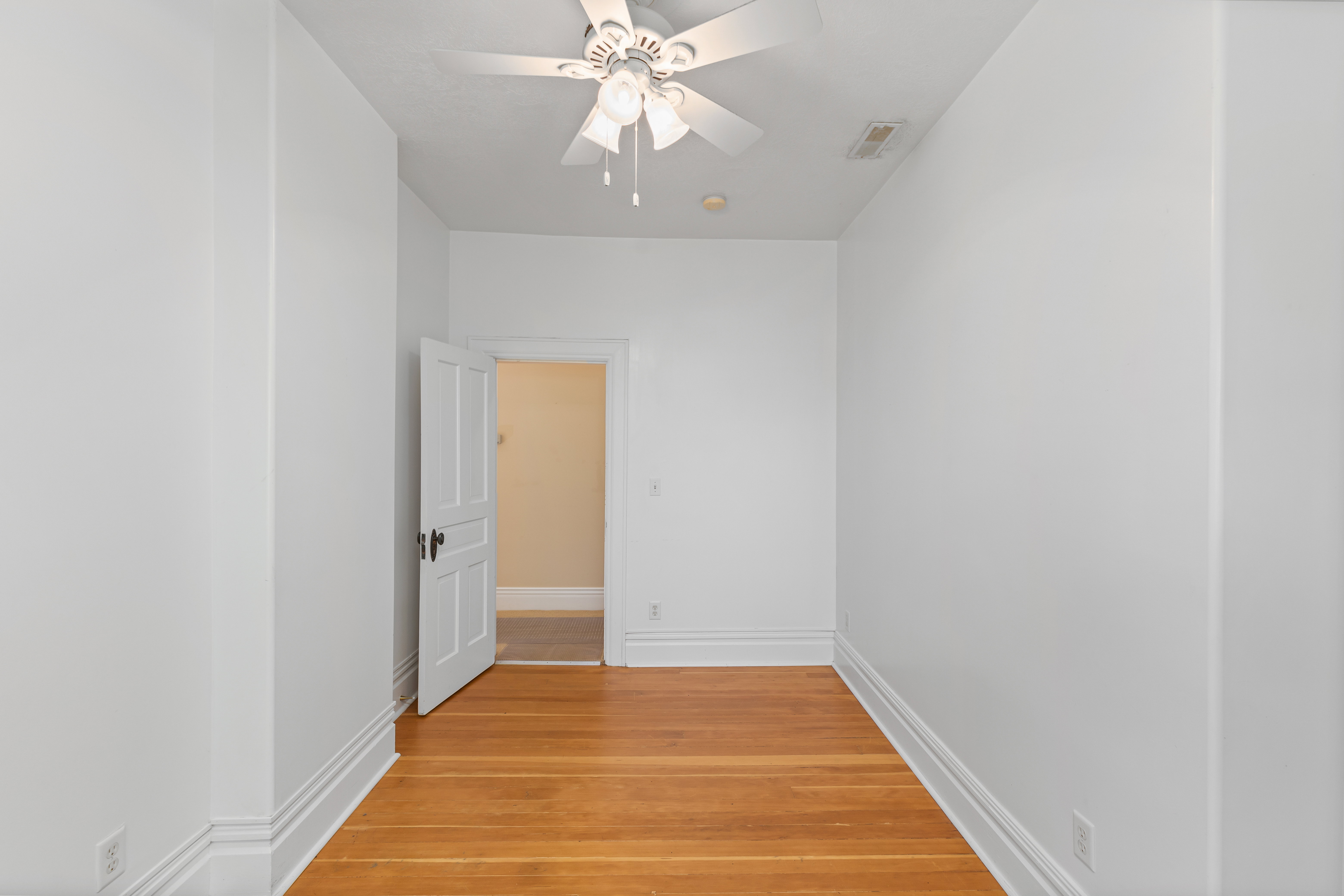 Empty room with light wood-style flooring and a ceiling fan