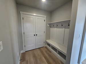 Mudroom with light wood-style flooring and baseboards
