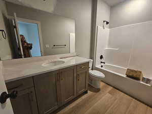 Bathroom with vanity, shower / washtub combination, and light wood finished floors
