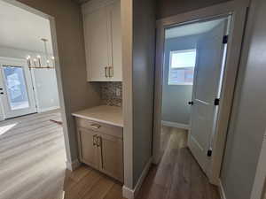 Hall featuring light wood-type flooring and a chandelier
