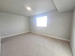 Carpeted empty room featuring baseboards