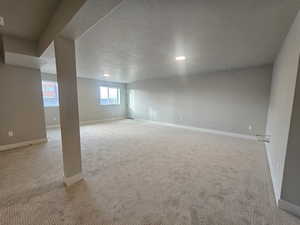 Basement featuring a textured ceiling, carpet, and recessed lighting