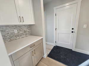 Doorway to outside with baseboards and wood finished floors