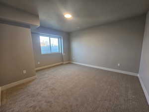 Carpeted spare room with baseboards and a textured ceiling