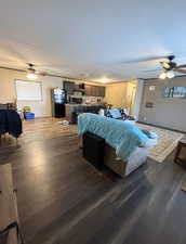 Living area featuring a ceiling fan and dark wood-type flooring