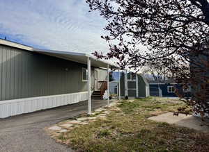 View of side of home with a lawn and a storage shed