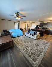 Bedroom featuring dark wood-type flooring, a ceiling fan, and freestanding refrigerator