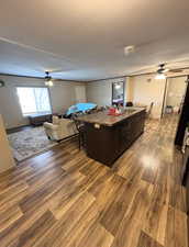 Recreation room featuring a ceiling fan and dark wood-style floors