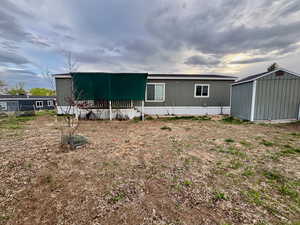 Rear view of property with a storage unit