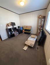 Carpeted home office with ornamental molding