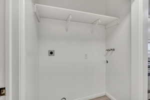 Washroom featuring electric dryer hookup, hookup for a washing machine, and wood finished floors