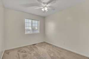 Spare room with light colored carpet and ceiling fan