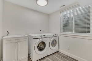 Laundry area featuring washer and dryer and light wood finished floors