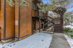 Snow covered property featuring stairs and a deck