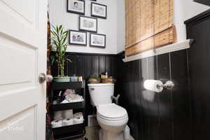 Bathroom with a wainscoted wall and toilet