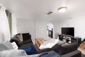 Carpeted living room with arched walkways