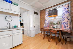 Dining space featuring brick wall and light wood-style flooring