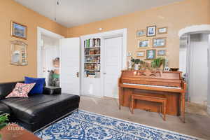 Living area with carpet floors and arched walkways