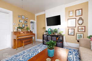 Carpeted living area featuring arched walkways and baseboards