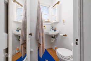 Half bath with light wood-style floors and a textured wall