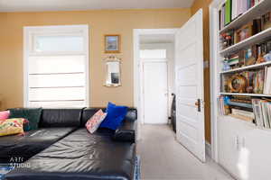 Living area featuring light carpet