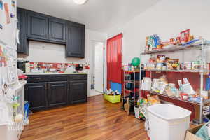 Kitchen with light countertops, dark wood finished floors, freestanding refrigerator, and decorative backsplash