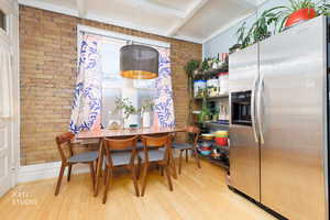 Dining room with brick wall and light wood-style floors