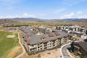 Contemporary multi-story residential building with private balconies and a brown shingle roof